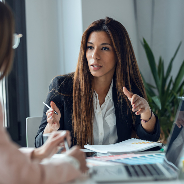 Shot of two fashion designers working with laptop and deciding details of clothes new collection in the sewing workshop.