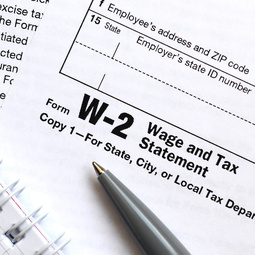 The pen and notebook on the tax form W-2 Wage and Tax Statement. The time to pay taxes